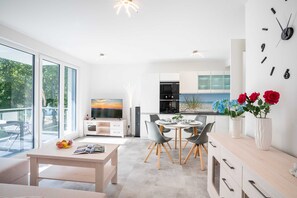 Een moderne keuken met een eethoek, grote ramen en uitzicht op de omgeving.