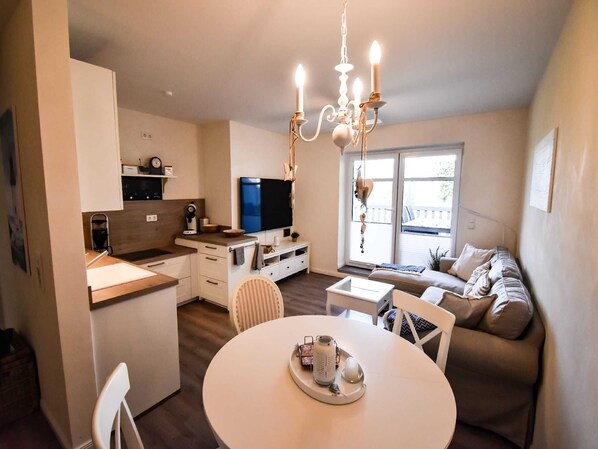 A modern apartment with a kitchen, dining area, and living room.