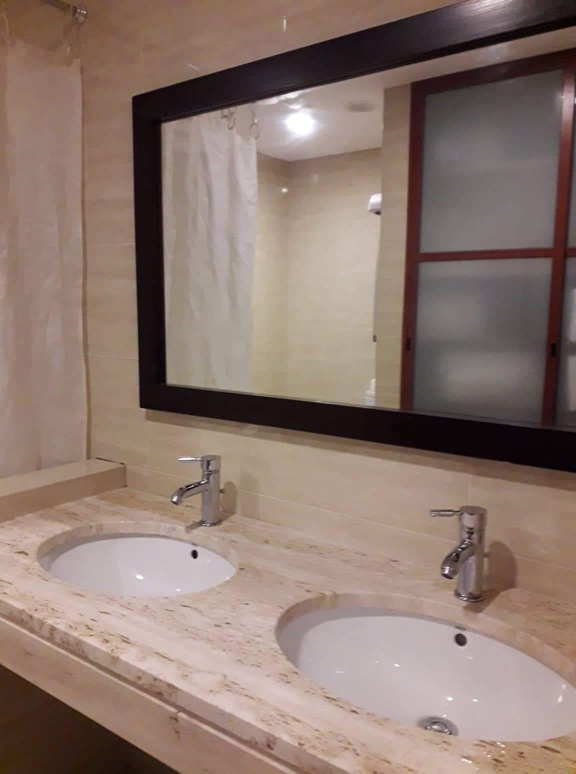 A bathroom with two sinks, a mirror, and a shower curtain.