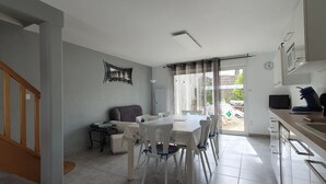 Uma sala ampla com uma mesa de jantar, um sofá e uma escada.