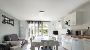 Um espaço compacto com área de refeições, cozinha compacta e sofá.