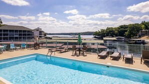 Ein Poolbereich mit Liegestühlen und Blick auf einen See.