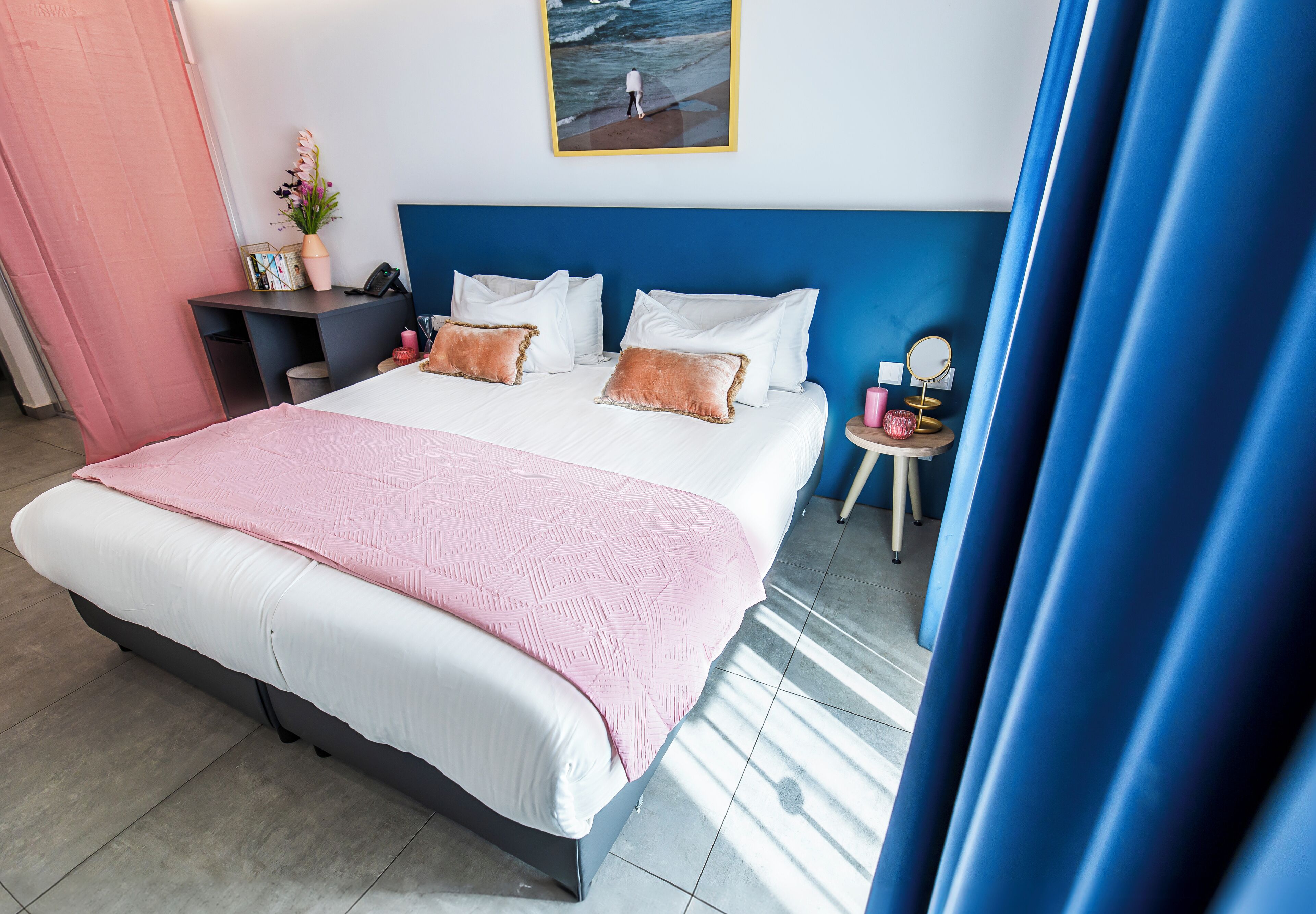 Un dormitorio ordenado con una cama grande, mesitas de noche y un pequeño escritorio.
