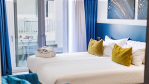 A hotel room with a bed, a chair, and a balcony view. -  Flamingo Hotel (St. Julian's)