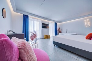 Ett modernt hotellrum med en stor säng, ett skrivbord och en soffa.