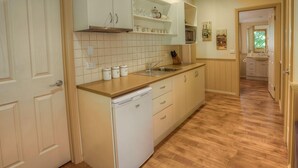 Eine Küche mit Geschirrspüler, Holzschränken und einer gefliesten Spritzschutzwand.