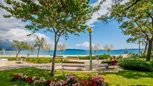 A park with benches, a lamppost, and a view of the sea. - Seafront Spacious Apt, 120 m2 Size, in the Center (Kastela)