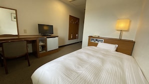 A hotel room with a bed, a desk with a television, a refrigerator, a chair, a wardrobe, and a bedside lamp. - Smile Hotel Nabar (Nabari)
