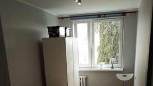 Ett kompakt vardagsrum med en soffa, ett litet bord och ett fönster med utsikt över grönområden.