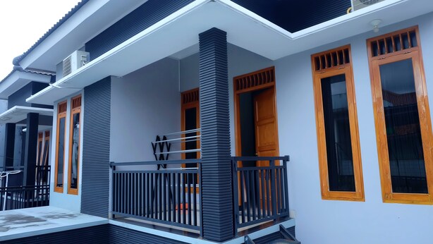Una casa moderna con un balcone, ampie finestre e un tetto piatto.