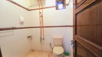 A small bathroom with a toilet, a shower, and a hand dryer.