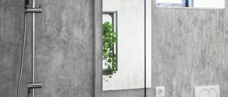 A modern bathroom with a shower, a sink, and a toilet.
