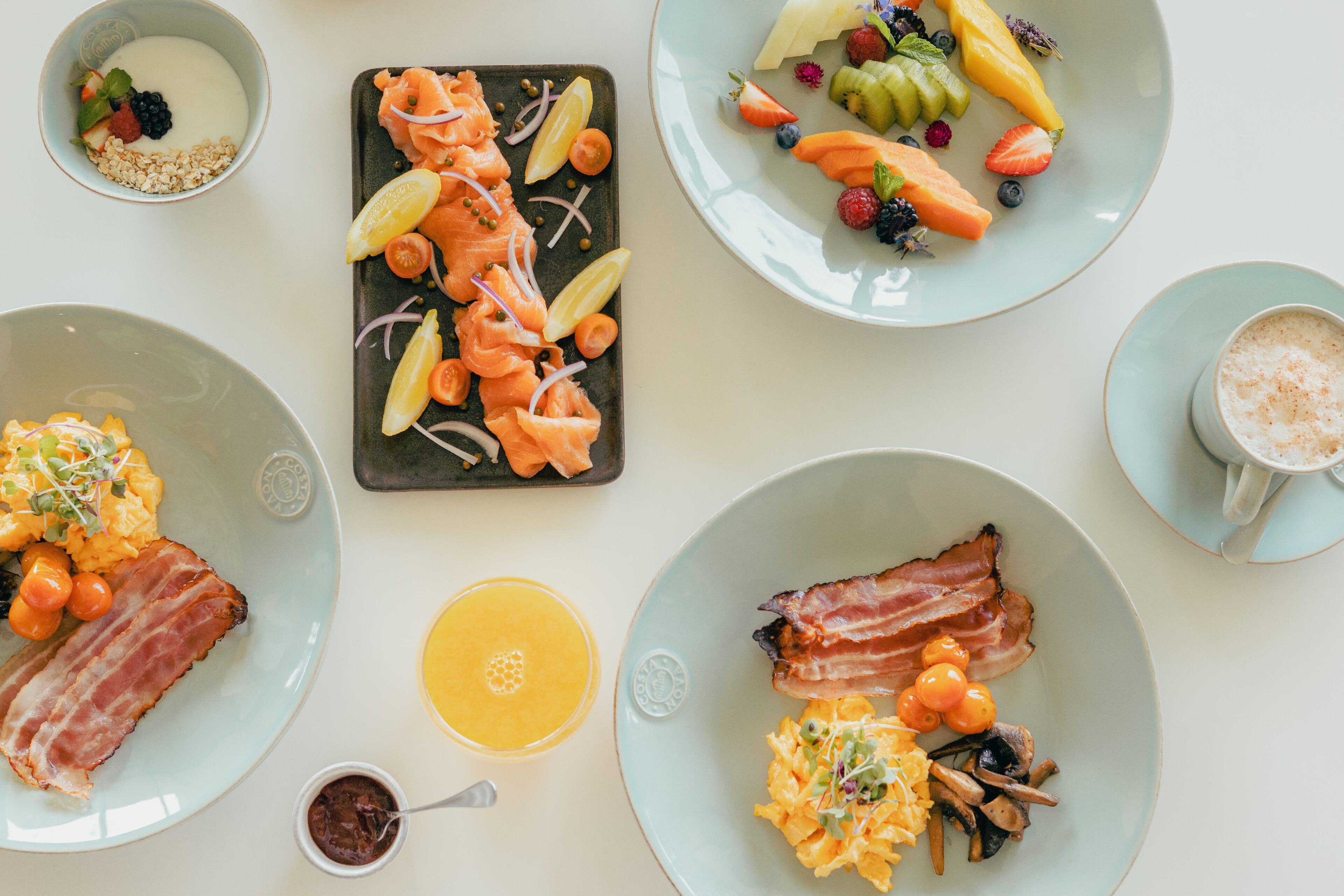 A breakfast buffet with various dishes including eggs, bacon, and fruits.