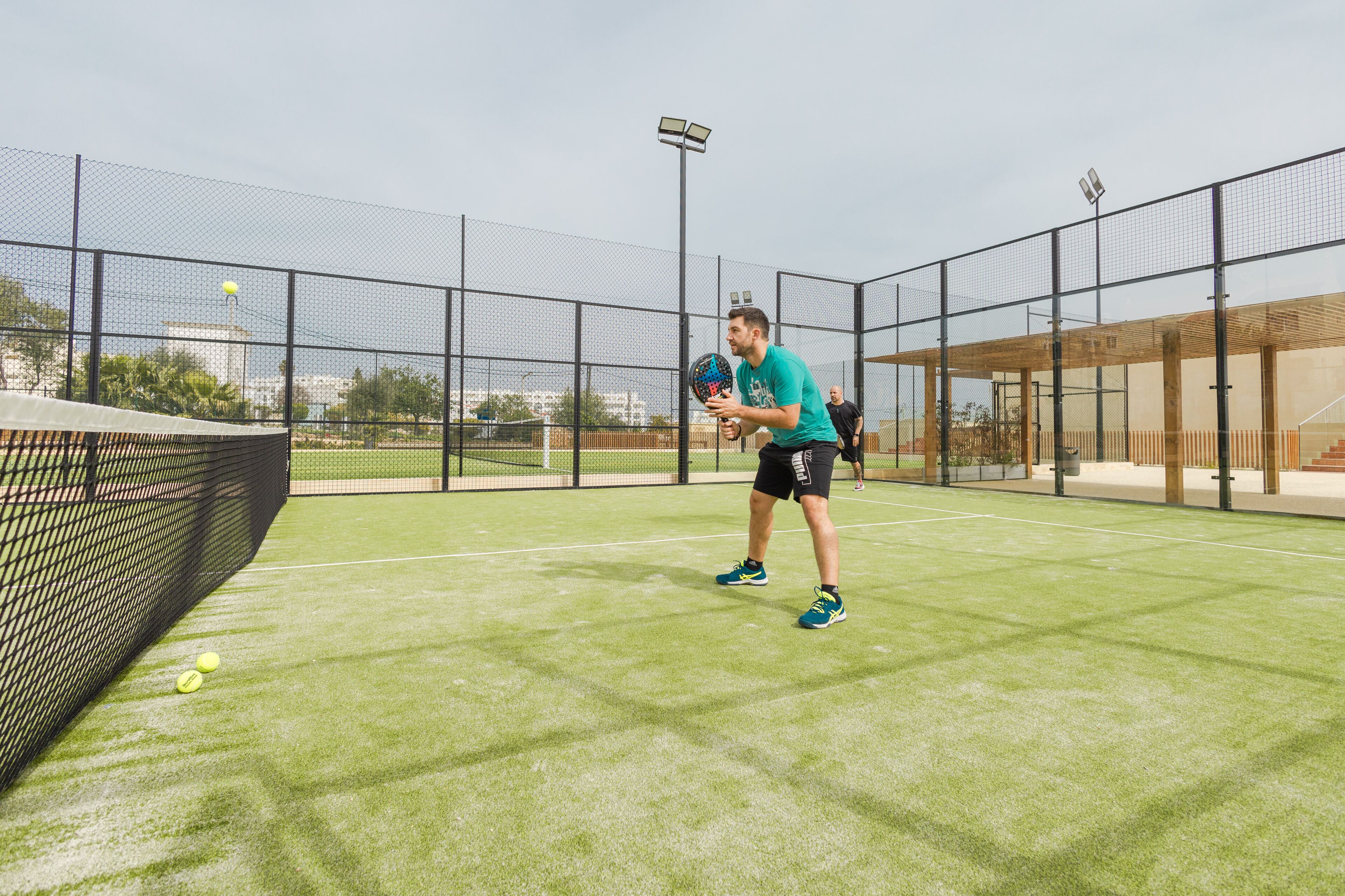 A tennis court with a net, a player, and a ball.