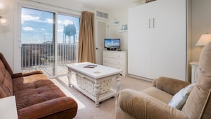 Ein Wohnzimmer mit Sofa, Couchtisch, Fernseher und Kleiderschrank.