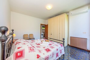 A bedroom with a bed, a radiator, a wardrobe, and a chair. - Villa Marilyn (Nesso)