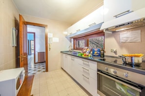 A kitchen with a microwave, oven, and a window with a view.