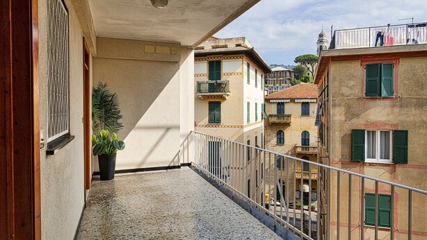 A balcony with a view of adjacent buildings, a potted plant, and a metal railing. - A due passi dal Porto di Santa Margherita Ligure by Wonderful Italy (Santa Margherita Ligure)
