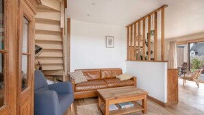 A spacious living room with a leather sofa, a blue armchair, and a wooden coffee table. - Bright house with large terrace in La Roche-Bernard (La Roche-Bernard)