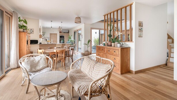 A spacious living area with a dining set, wicker furniture, and a wooden staircase. - Bright house with large terrace in La Roche-Bernard (La Roche-Bernard)