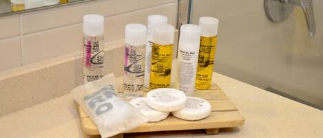 Una encimera de baño con artículos de aseo, incluyendo botellas y una pastilla de jabón.
