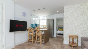 A modern living room with a dining area, a kitchen, and a bedroom. - HomeForGuest Ático Cecilia con terraza y vistas al mar en Los Cristianos (Los Cristianos)