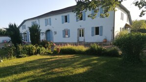 A white building with blue shutters, a central entrance, and a well-maintained lawn. - Maison Héouguère 29km from Dax and 15km from Orthez, and 5min from Amou (Castel-Sarrazin)