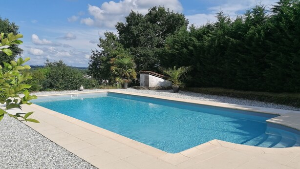 A rectangular swimming pool with clear blue water, surrounded by a pebble border and a tiled deck. - Maison Héouguère 29km from Dax and 15km from Orthez, and 5min from Amou (Castel-Sarrazin)