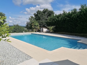 A rectangular swimming pool with clear blue water, surrounded by a pebble border and a tiled deck. - Maison Héouguère, 29 km from Dax, 15 km from Orthez, and 5 minutes from Amou (Castel-Sarrazin)