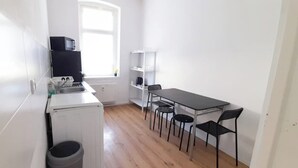 Une cuisine compacte équipée d’un évier, d’un four à micro-ondes et d’un petit coin repas avec des chaises.