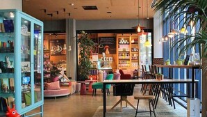 Ein modernes Interieur mit einer zentralen Sitzgruppe, einer Glaskabine zur Präsentation und verschiedenen Pflanzen.