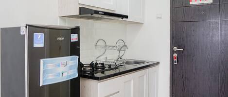 A compact kitchen with a refrigerator, stove, and sink.