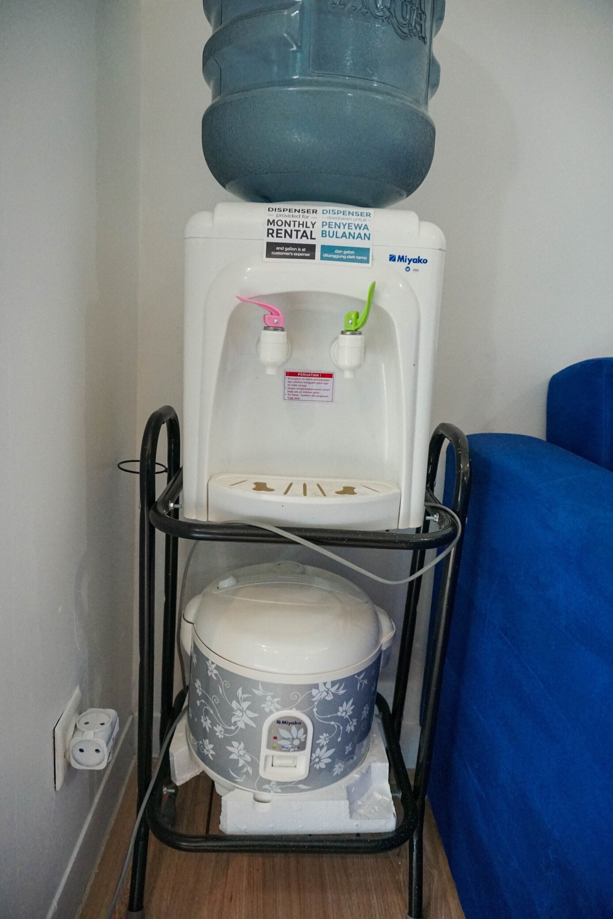 A water dispenser and toilet on a stand.
