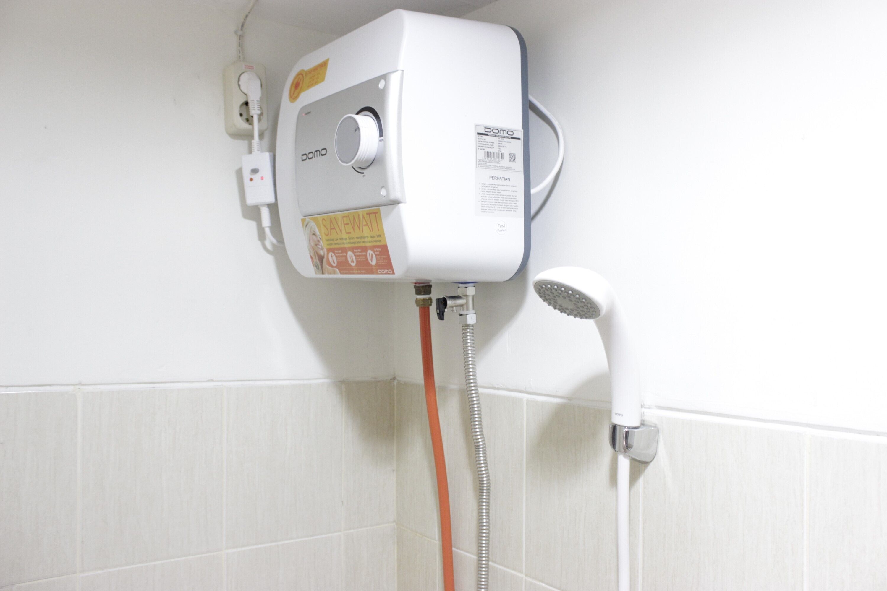 Divisão de chuveiro branca com painel de controle, chuveiro manual e mangueira flexível.