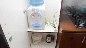 A water dispenser, a kettle, and a stove in a small kitchen area. - Comfort and Homey Studio Kebagusan City Apartment (Jakarta)