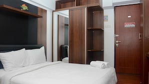 A hotel room with a bed, a wardrobe, and a door. - Comfort and Homey Studio Kebagusan City Apartment (Jakarta)