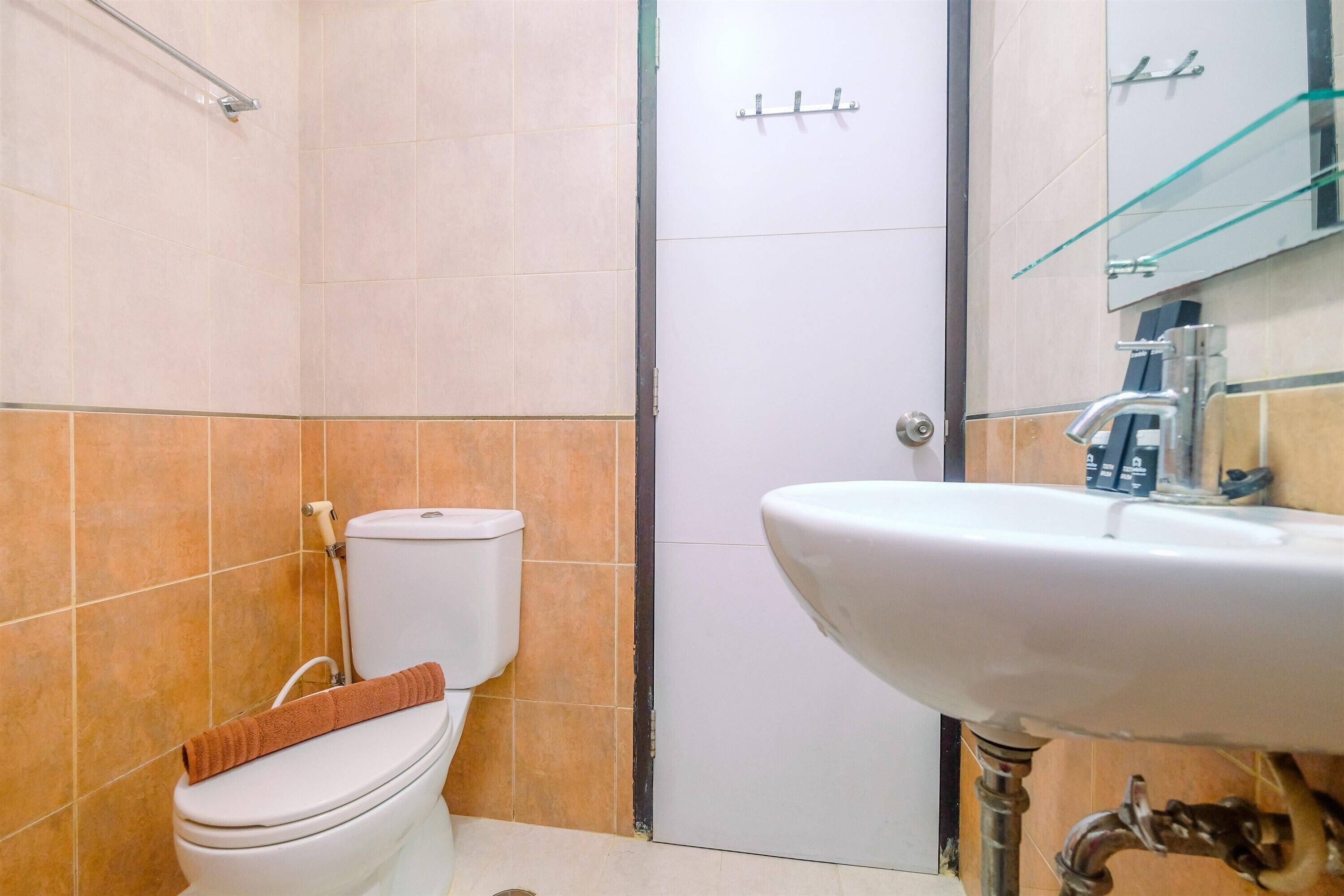 A bathroom with a white toilet, a sink, and a glass shower enclosure.
