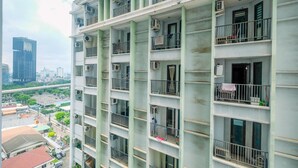 A multi-story residential building with balconies, air conditioning units, and a view of the cityscape. - Comfort Studio Tamansari Sudirman Apartment (Jakarta)