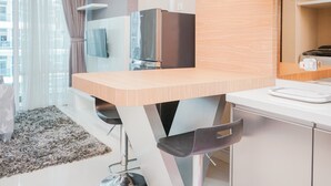 A modern kitchen with a wooden countertop, stainless steel appliances, and a built-in oven. - Great Choice 1BR at Brooklyn Alam Sutera Apartment (South Tangerang)