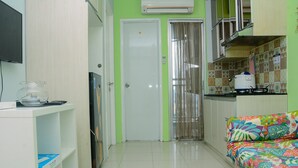A compact kitchen with a refrigerator, a microwave, and a coffee maker on the counter. - Comfortable 2BR Bassura City Apartment near Bassura Mall (Jakarta)