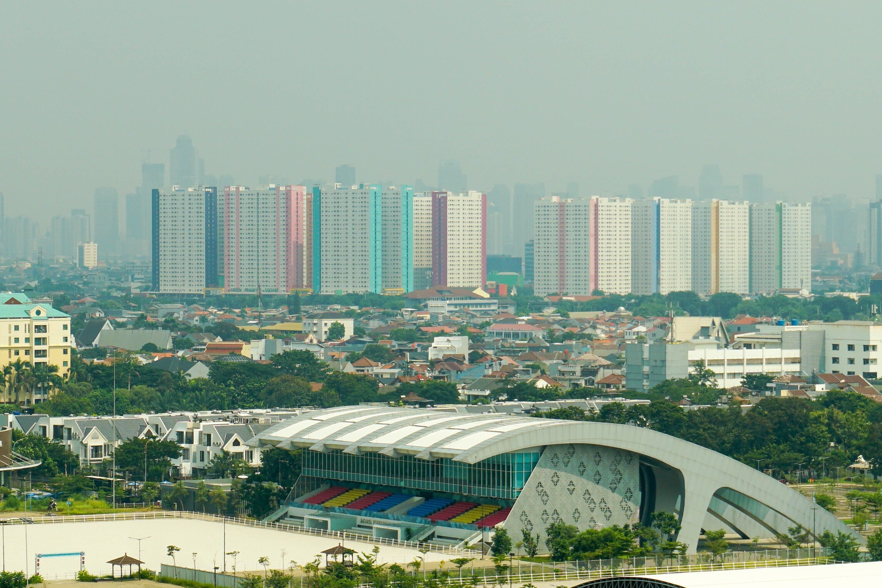 Un estadio con un techo curvo distintivo y asientos coloridos.