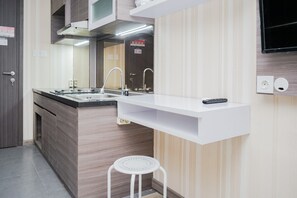 Una cocina moderna con estufa integrada, dos fregaderos y una encimera blanca.
