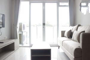 Una sala de estar moderna con un sofá, una mesa de centro y un televisor sobre un mueble.