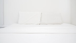 A neatly made bed with white bedding and pillows. - Comfy 2BR Apartment at Parkland Avenue (South Tangerang)