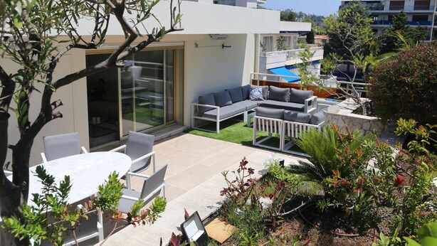 A modern outdoor living area with a pool, lounge chairs, and a dining table. - Rooftop Croisette/alexandre III (CANNES)