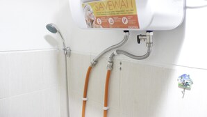 A shower with a water-saving device and a wall-mounted faucet.