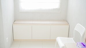 Une pièce blanche avec un banc et une chaise.