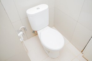 A modern bathroom with a standard toilet and modern plumbing.
