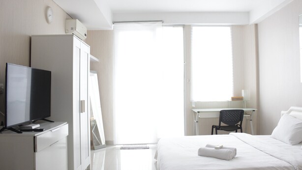 Une chambre d’hôtel équipée d’un lit, d’un bureau, d’une chaise, d’une télévision et d’une armoire.