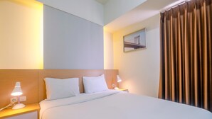Una habitación de hotel con una cama, dos mesitas de noche, una lámpara de noche, un cuadro en la pared y una cortina.